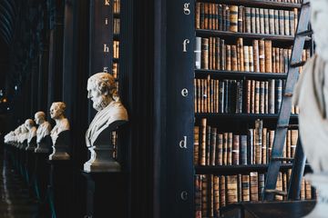 Marble busts next to bookcases full of books
